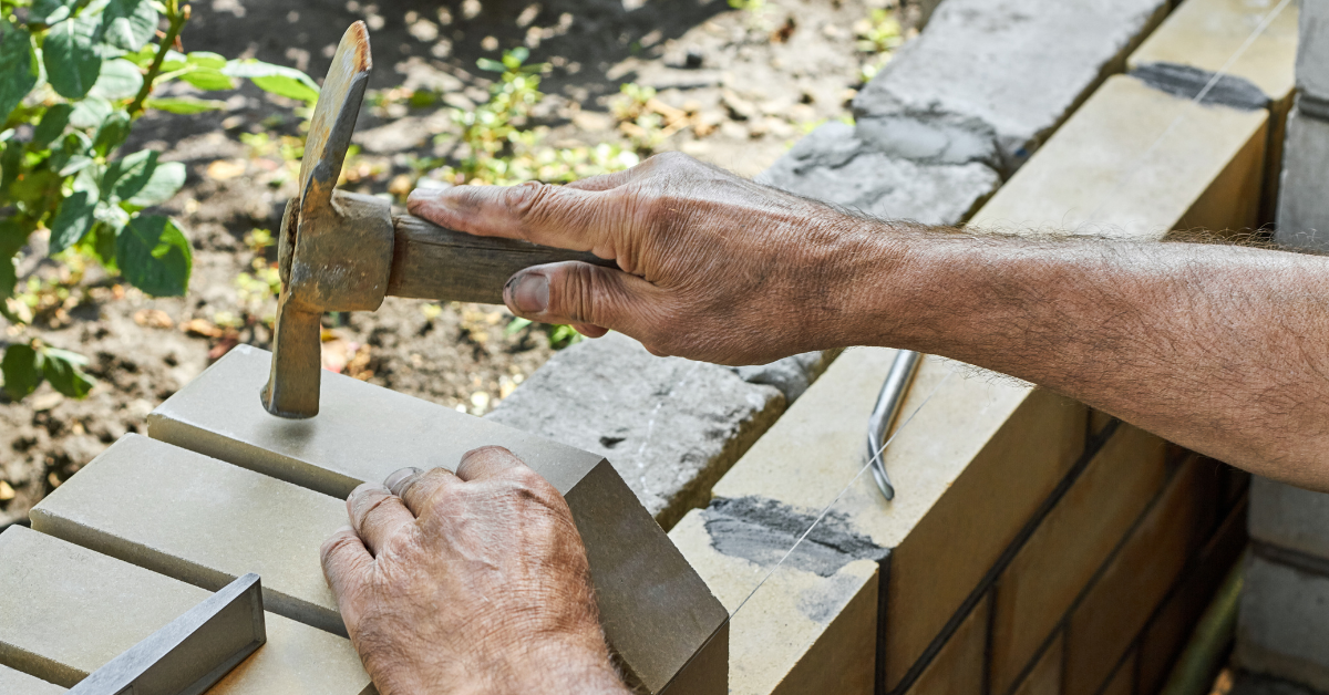 Man using a brick hammer to lay bricks What is a brick hammer?